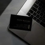 Professionelle Visitenkarte Gold Design – Goldene Visitenkarte liegt auf einem Laptop, symbolisiert modernes Business und luxuriöses Design.