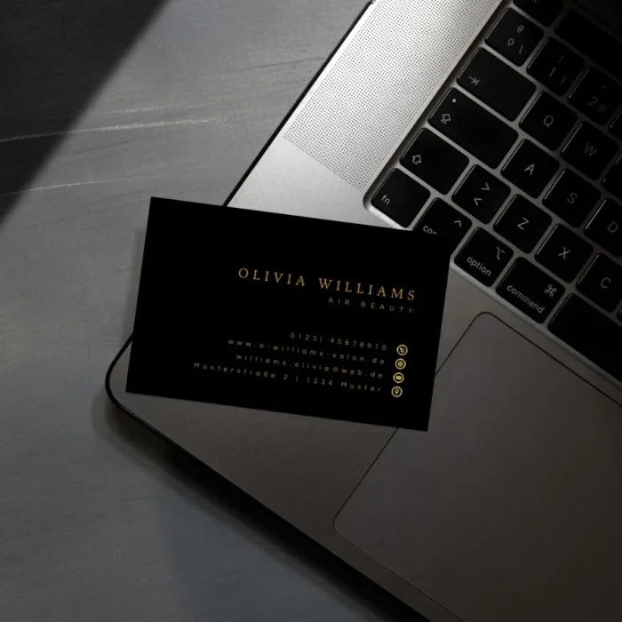 Professionelle Visitenkarte Gold Design – Goldene Visitenkarte liegt auf einem Laptop, symbolisiert modernes Business und luxuriöses Design.