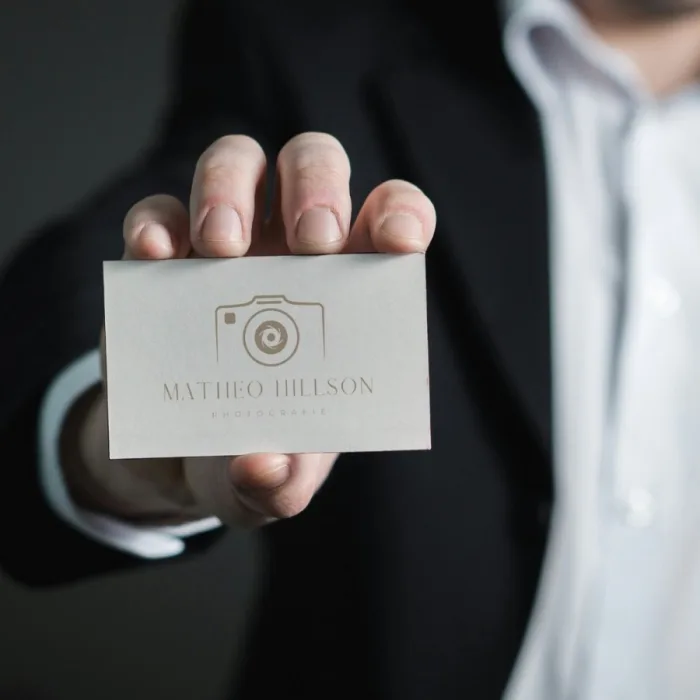 Professionelle Visitenkarte – Rück- und Vorderseite der Visitenkarte in der Hand eines im Business-Stil gekleideten Mannes, der Professionalität und Vertrauen ausstrahlt.