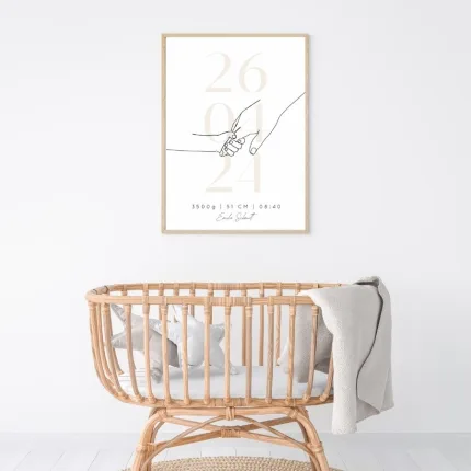 Gerahmtes Geburtserinnerungsbild in beige an der Wand mit allen Geburtsdaten (Name, Datum, Größe, Gewicht, Uhrzeit) über einem weißen Kinderbett – Zeitlose Wanddekoration für das Kinderzimmer