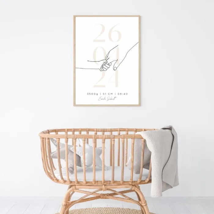 Gerahmtes Geburtserinnerungsbild in beige an der Wand mit allen Geburtsdaten (Name, Datum, Größe, Gewicht, Uhrzeit) über einem weißen Kinderbett – Zeitlose Wanddekoration für das Kinderzimmer