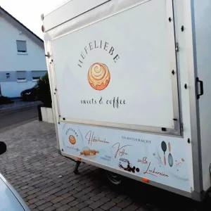Logo von alinsalettering auf dem mobilen Backanhänger von Hefeliebe Sweets & Coffee