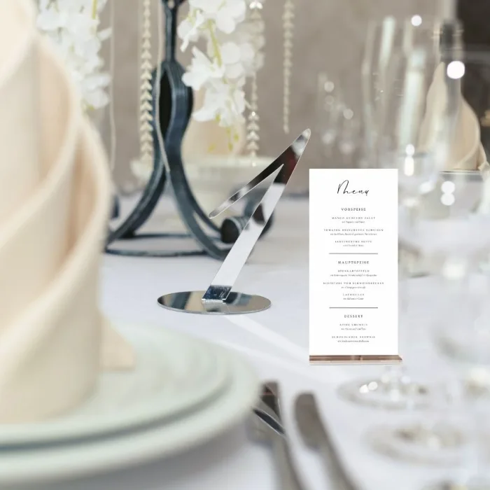 Festliche Menükarte im Aufsteller auf gedeckter Feiertafel – mit mehreren Gängen